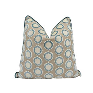 a single pillow with a repeating pattern of blue and white circles on a beige background.