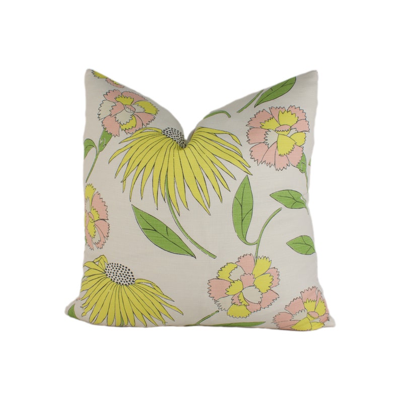 May include: A white pillow with a floral pattern featuring pink and yellow flowers with green leaves.
