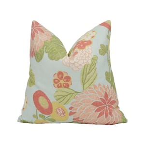 May include: A light blue pillow with a floral pattern featuring pink, red, and yellow flowers on a light blue background.
