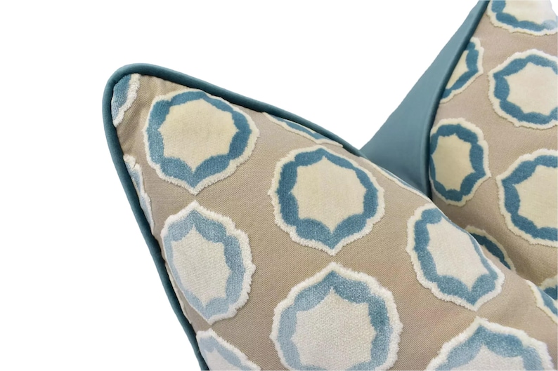 a close-up view of a decorative pillow with a repeating pattern of blue and beige geometric shapes.