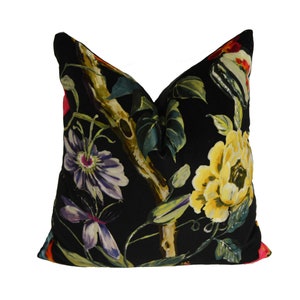 May include: Black velvet pillow with a floral print featuring yellow, red, pink, purple, and green flowers and leaves.