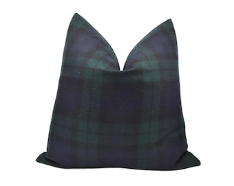 May include: A square pillow with a classic plaid pattern in shades of navy blue and forest green. The pillow has a soft, textured appearance and is designed for decorative use on a bed or sofa.