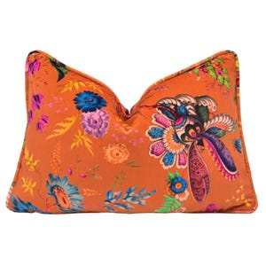 May include: Orange throw pillow with a colorful floral and paisley pattern.