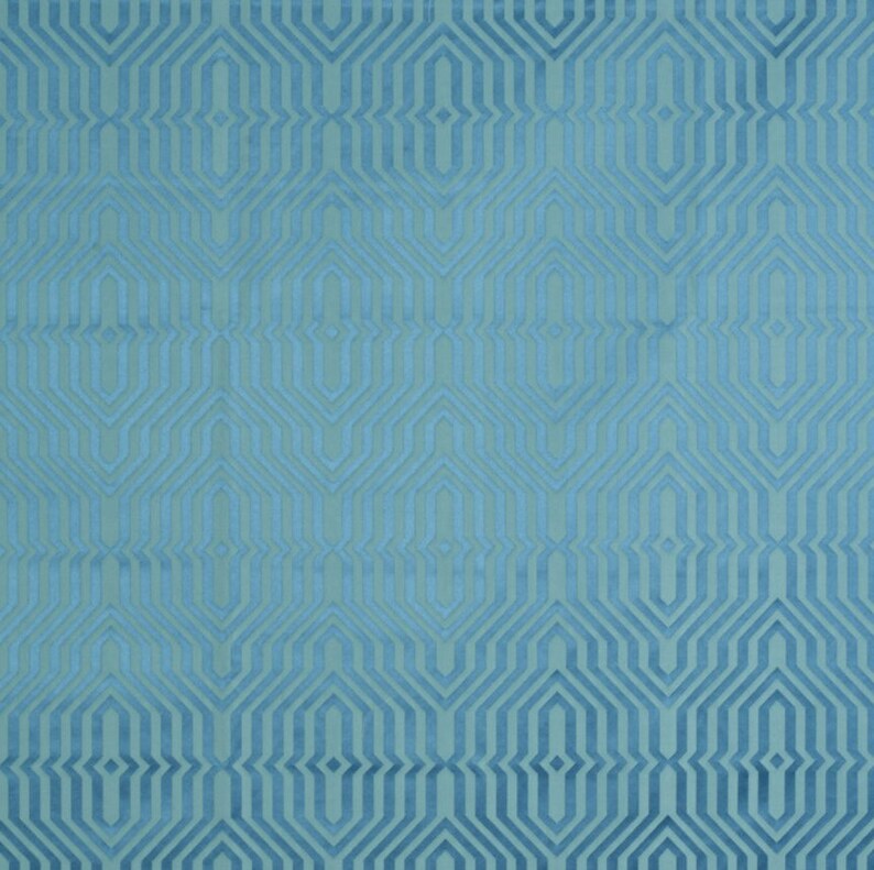 May include: A teal blue fabric with a geometric pattern of overlapping hexagons and diamonds.