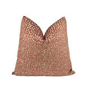 May include: A decorative throw pillow with a textured leopard print pattern in shades of brown and tan. The pillow has a soft, plush appearance and is designed for home decor.