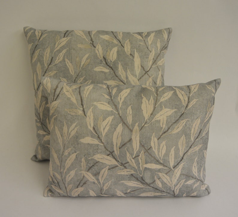May include: Two decorative throw pillows with a light blue background and a white leaf pattern.