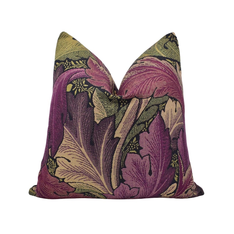 a purple and green floral pillow on a white background