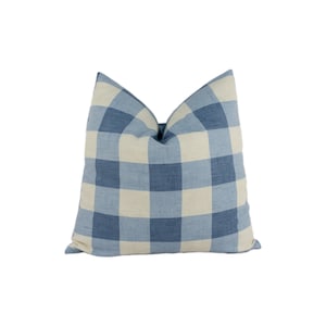 Könnte beinhalten: Ein blaues und weißes kariertes Kissen. Das Kissen ist aus einem weichen, gewebten Stoff.