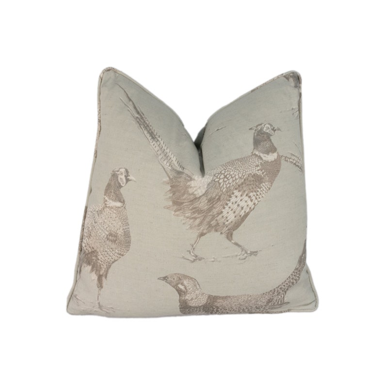 May include: A light blue throw pillow with a brown pheasant print. The pillow features three pheasants in a walking pose.
