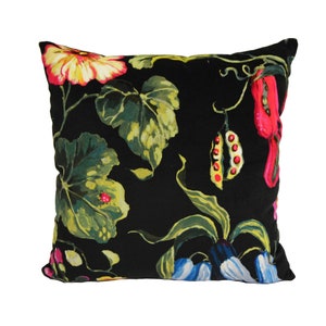 May include: Black square throw pillow with a floral pattern featuring red, yellow, green, and blue flowers and leaves.