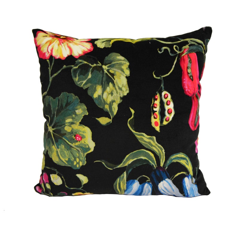 May include: Black square throw pillow with a floral pattern featuring red, yellow, green, and blue flowers and leaves.