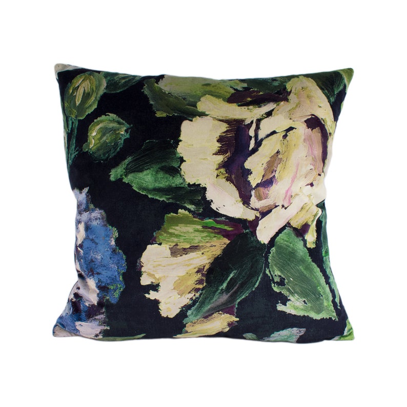 May include: A black velvet pillow with a floral print featuring large, abstract flowers in shades of green, yellow, and purple.