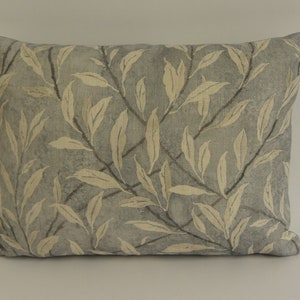 May include: A light blue throw pillow with a cream-colored leaf pattern.
