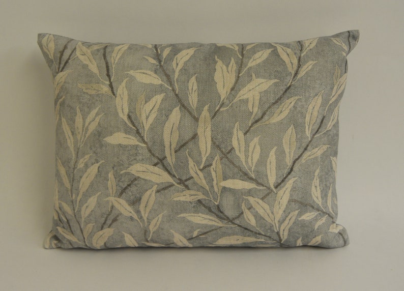 May include: A light blue throw pillow with a cream-colored leaf pattern.