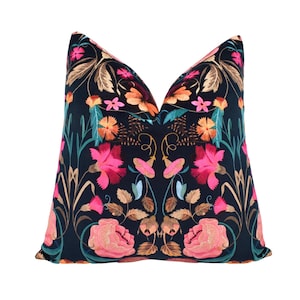a black and pink pillow with flowers on it