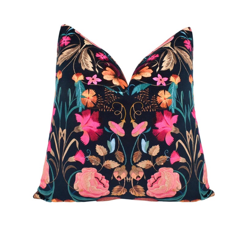 a black and pink pillow with flowers on it