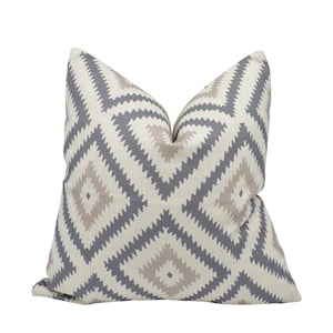 May include: A decorative throw pillow with a geometric pattern in shades of gray, beige, and white. The pillow features a diamond-shaped design with a subtle textured fabric.