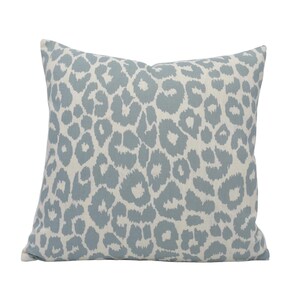 a blue and white leopard print pillow on a white background