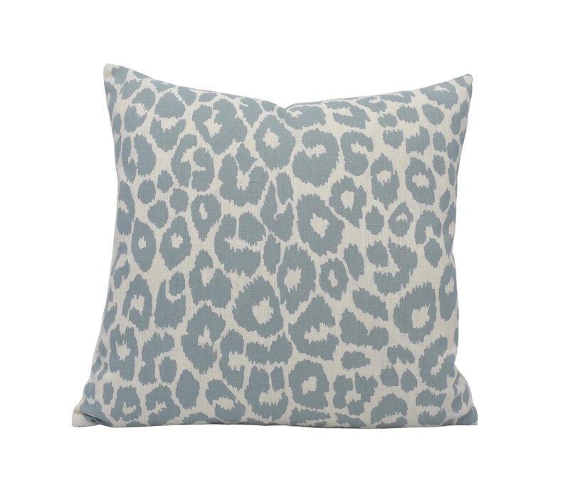 a blue and white leopard print pillow on a white background