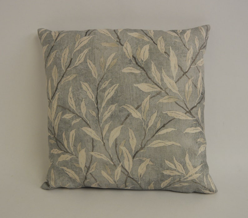 May include: A gray and white patterned throw pillow with a leaf design.
