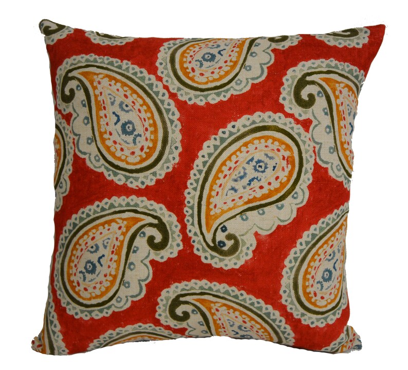May include: Red throw pillow with a paisley pattern in shades of green, blue, and yellow.