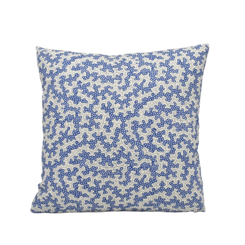 a blue and white pillow on a white background