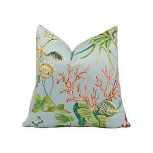 May include: A light blue cushion with a floral print featuring coral, green leaves, and yellow flowers. The cushion has a subtle sheen and a soft, comfortable feel.