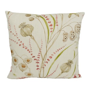 May include: A square throw pillow with a cream-colored background and a floral pattern. The flowers are in shades of green, brown, and pink. The pillow is made of a soft, linen-like fabric.