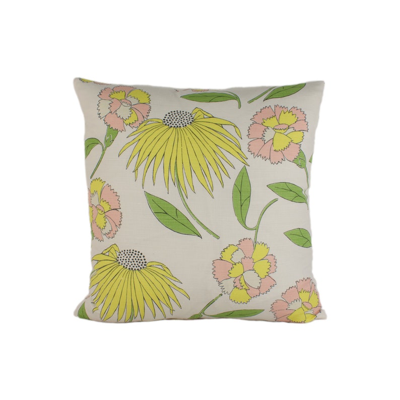 May include: A white pillow with a floral pattern. The flowers are yellow, pink, and green. The pillow is made of a soft, comfortable fabric.