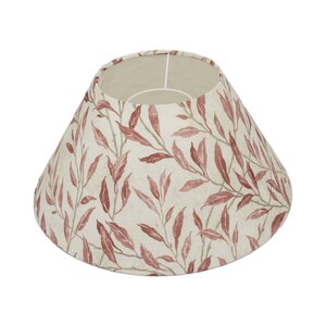 May include: A cone-shaped lampshade with a cream background and a red leaf pattern.