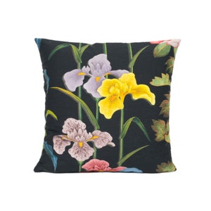 May include: Black pillow with a floral pattern featuring yellow, purple, and pink irises on a dark green background.