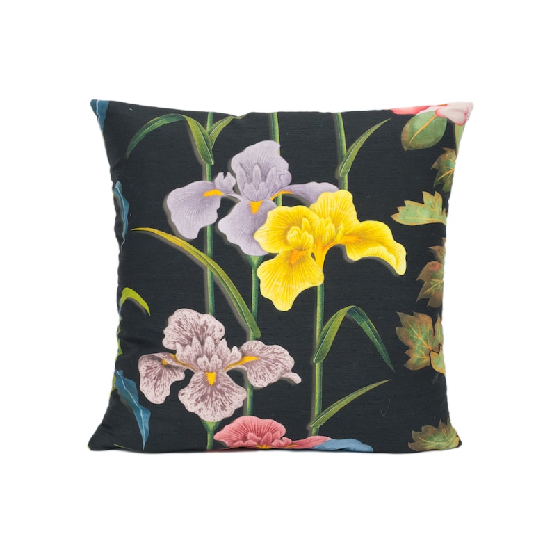 May include: Black pillow with a floral pattern featuring yellow, purple, and pink irises on a dark green background.