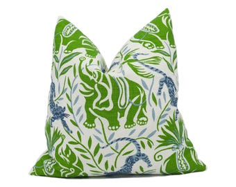 May include: Green and blue patterned cushion with a design of elephants, tigers, and leaves on a white background.