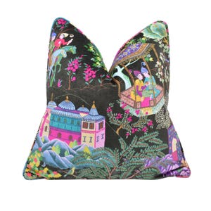 May include: A black velvet pillow with a colorful, intricate design featuring a scene of people riding horses, a building with a dome, and trees. The design is reminiscent of traditional Turkish art.