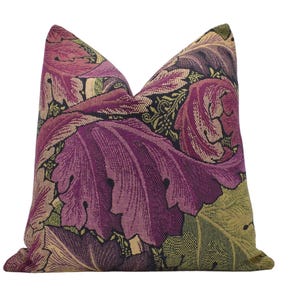 a purple and green floral pillow on a white background