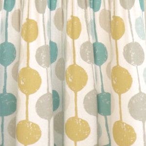 May include: White fabric with a repeating pattern of large, yellow, blue, and gray circles. The circles have a textured, hand-painted look.