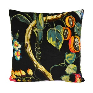 May include: Black throw pillow with a colorful floral pattern featuring a vine with leaves, flowers, and fruit. The pillow has a dark background with bright yellow, orange, red, and green accents.
