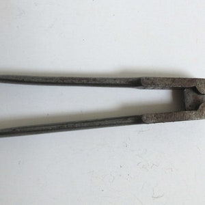 Könnte beinhalten: Ein antikes Werkzeug zum Crimpen von Geschossen aus Metall mit zwei langen Armen und einem Crimpmechanismus in der Mitte.