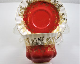 Xícara e pires Royal Albert em porcelana com decoração em vermelho brilhante e dourado, fabricados na Inglaterra.