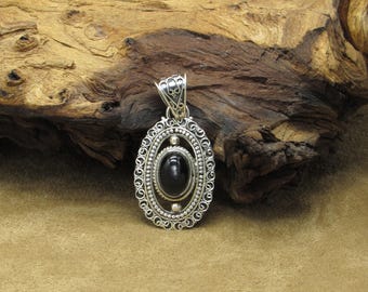 May include: A silver pendant with an oval-shaped black gemstone set in a filigree design.