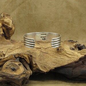 May include: Silver bracelet with a textured design and the inscription "remarkable" on the back.