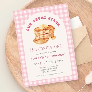Puede incluir: Invitación con estampado de cuadros rosa y blanco con una ilustración de dibujos animados de una pila de panqueques con mantequilla y jarabe. El texto dice "Our Short Stack is Turning One. Please join us to celebrate Hailey's 1st Birthday. Sat 02.15 12pm. The Peterson's Residence 413 Grapevine Blvd Dallas, TX 90754. RSVP to Katie at 204.253.2928 by 2/1."