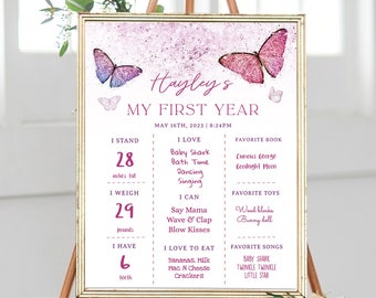Puede incluir: Un póster imprimible de color rosa y morado para el primer cumpleaños con mariposas. El póster incluye el nombre del niño, Hayley, y detalles sobre su primer año, incluyendo su altura, peso, comidas favoritas, canciones y juguetes.