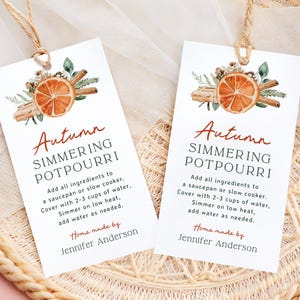 May include: Two rectangular white tags with the text "Autumn Simmering Potpourri" and instructions. Each tag features a watercolor illustration of a dried orange slice, cinnamon sticks, and greenery, tied with twine.