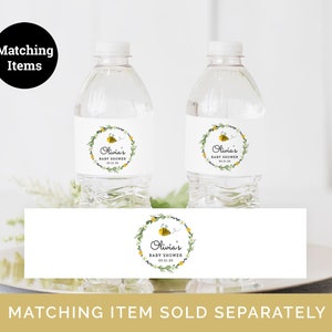 Puede incluir: Dos botellas de agua de pl&aacute;stico transparente con etiquetas blancas que muestran un dise&ntilde;o de abeja y corona de flores. Las etiquetas dicen "Olivia's Baby Shower" e incluyen la fecha "03.11.10". Una etiqueta a juego con el mismo dise&ntilde;o se muestra debajo de las botellas.