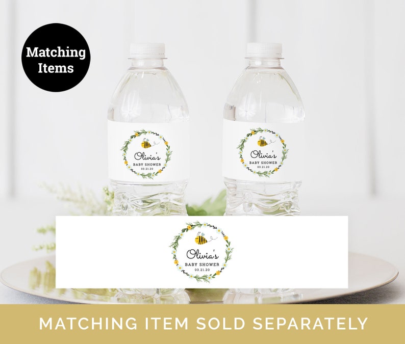 Puede incluir: Dos botellas de agua de pl&aacute;stico transparente con etiquetas blancas que muestran un dise&ntilde;o de abeja y corona de flores. Las etiquetas dicen "Olivia's Baby Shower" e incluyen la fecha "03.11.10". Una etiqueta a juego con el mismo dise&ntilde;o se muestra debajo de las botellas.