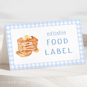 Könnte beinhalten: Editierbares Lebensmitteletikett mit einem blauen und weißen Gingham-Rand. Das Etikett zeigt eine Aquarell-Illustration eines Stapels Pfannkuchen mit Butter und Sirup. Der Text "editable FOOD LABEL" ist in Blau gedruckt.