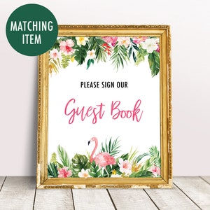 May include: A gold framed sign with a tropical floral border and a pink flamingo. The sign says "Please sign our Guest Book".
