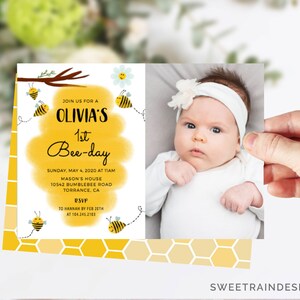 Puede incluir: Una invitaci&oacute;n de primer cumplea&ntilde;os de abejas amarilla y blanca con una foto de una ni&ntilde;a. La invitaci&oacute;n dice "&Uacute;nete a nosotros para el 1er cumplea&ntilde;os de Olivia" e incluye la fecha, la hora y el lugar de la fiesta. Tambi&eacute;n se incluye informaci&oacute;n de RSVP.