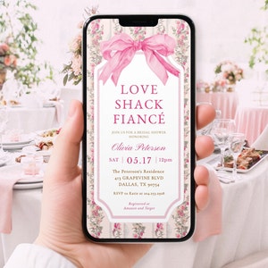 Könnte beinhalten: Eine rosafarbene und weiße Einladung zu einer Bridal Shower mit einer rosafarbenen Schleife und einem Blumenmuster. Die Einladung lautet "Love Shack Fiancé" und enthält Datum, Uhrzeit und Ort der Veranstaltung. Außerdem enthält sie den Namen der Braut, Olivia Peterson, und die RSVP-Informationen.